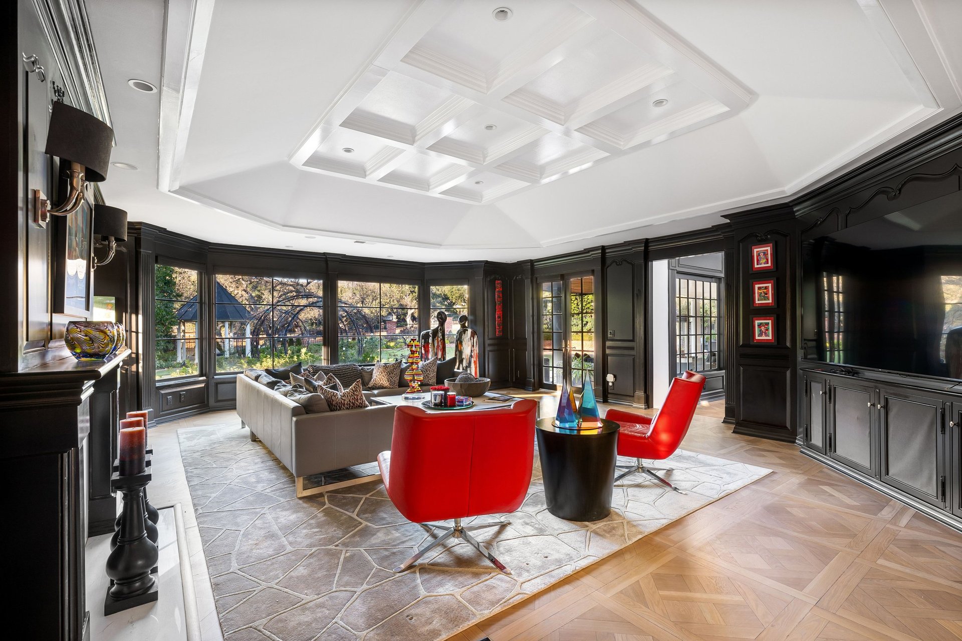 An elegant living room with modern decor, large windows, and artistic accents in a luxury home